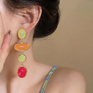 Detailed close-up showing colorful resin oval dangle earrings in a vintage gold-tone setting