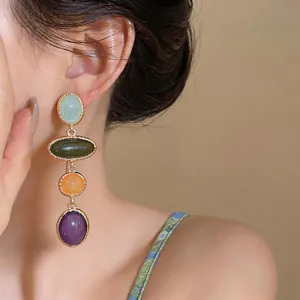 Detailed view of colorful oval resin drop earrings with a vintage palace style design