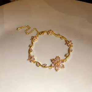 Détail d'un bracelet plaqué or 18 carats avec d'élégantes fleurs en zircon rose