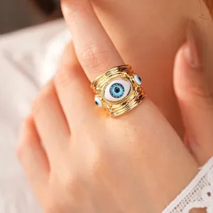 Statement chunky gold-tone open ring featuring multiple blue resin evil eye motifs