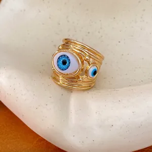 Chunky gold-plated open ring with blue resin evil eye charms in a vintage style.