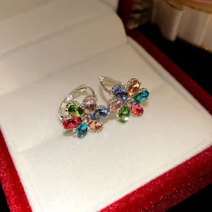 Detailed view of elegant flower earrings featuring colorful oval gemstones in a silver setting