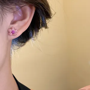 Detail view of pink star-shaped stud earring with sparkling rhinestone worn on ear