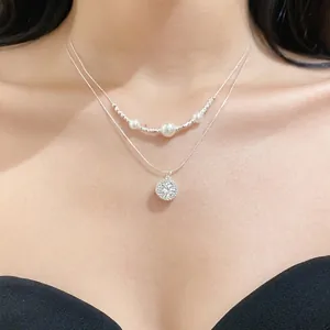 Elegant double-layered silver necklace featuring white pearls and a star zircon pendant on model