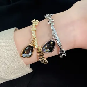 Irregular gold and silver bracelets with dark triangular crystal charms set