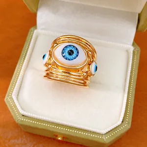 Macro detail of a golden resin evil eye ring with blue iris detail in a jewelry box