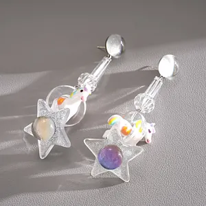 Detail view of dopamine style unicorn and star resin earrings with silver needles