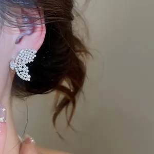 Vue détaillée d'une boucle d'oreille papillon évidée avec des perles et des cristaux élégants