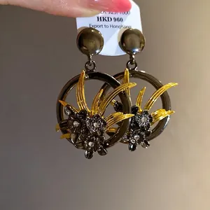 Vintage hollow flower pendant earrings with sparkling rhinestones in gold and black.