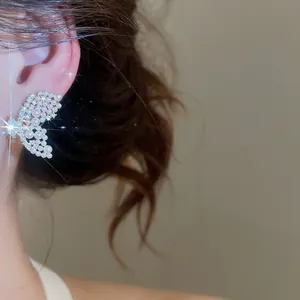 Gros plan sur d'élégantes boucles d'oreilles papillon avec perles et strass brillants