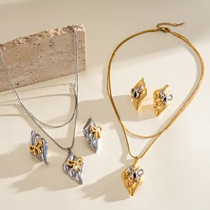 Detail of vintage stainless steel jewelry sets with bow pendants in gold and silver finishes
