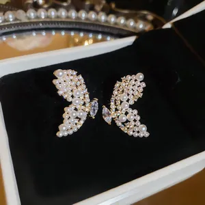 Vue macro détaillée d'élégantes boucles d'oreilles papillon avec perles et cristaux