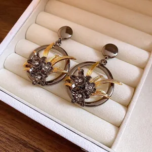 Vintage hollowed floral pendant earrings with sparkling rhinestones in a white jewelry case