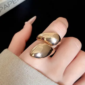 Irregular gold twisted drop ring with polished metal finish for retro fashion style