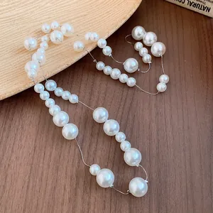 Close-up detail of a French vintage pearl necklace with varying bead sizes on wood