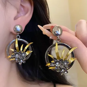 Close-up detail of vintage silver and gold floral hoop earrings with shiny rhinestones