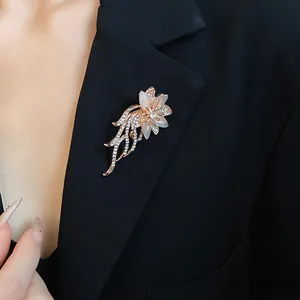 Macro di un'elegante spilla a fiore con strass e pietra occhio di gatto su revers nero