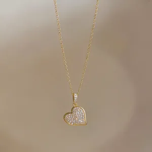 Detail einer eleganten Gold-Herzanhänger-Halskette mit schimmernden Zirkonsteinen