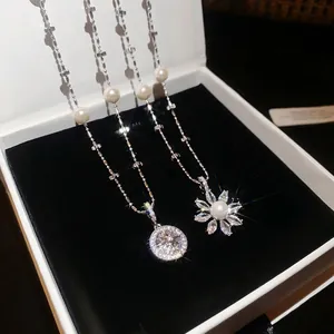 Elegant silver necklaces with flower and star pendants with pearls in a jewelry box