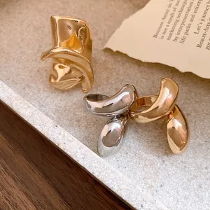 Macro detail of irregular distorted metal rings with vintage gold and silver finishes.