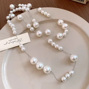Elegant long pearl necklace featuring mixed size beads on a silver-tone chain detail