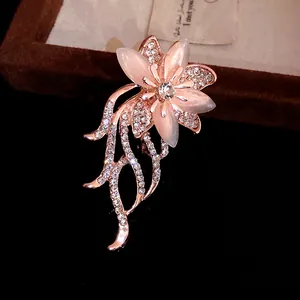 Primo piano di un'elegante spilla a fiore con pietre occhio di gatto rosa e strass lucidi