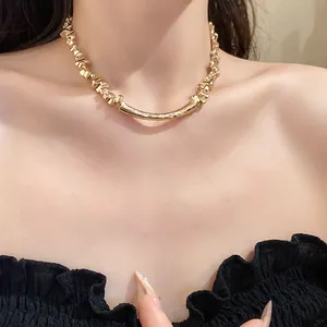 Close-up of elegant gold choker necklace with irregular geometric links and rhinestones.