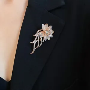Vista dettagliata di un'elegante spilla a fiore con pietre occhio di gatto su blazer nero
