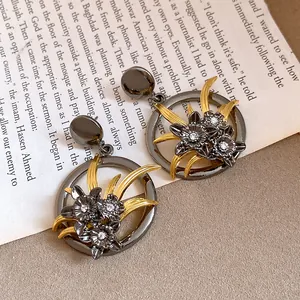 Detailed view of vintage hollow flower earrings with rhinestones and golden accents.