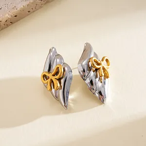 Detailed close-up of vintage silver stainless steel earrings with gold bow accents