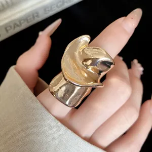 Detailed close-up view of a vintage gold irregular twisted metal ring on a finger