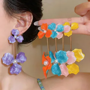 Detailed macro view of vibrant enamel flower earrings with elegant pearl centers