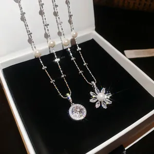 Close-up of elegant flower and star pendants with pearls and sparkling zircon stones