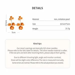 Detail view of orange flower drop earrings with size and material specifications