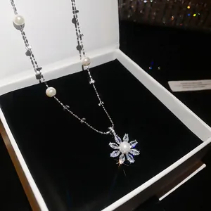 Close-up detail of elegant flower pendant necklace with shimmering zircons and pearls