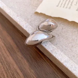 Close-up detail of silver irregular distorted water drop ring with polished finish