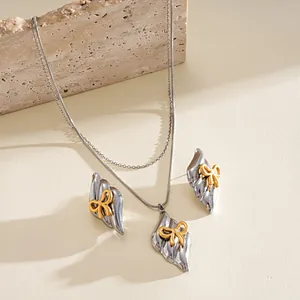 Close-up of vintage style stainless steel necklace and earrings set with golden bows