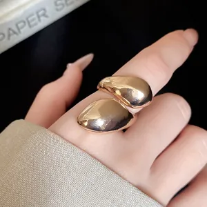 Close-up of a stylish irregular gold drop twisted ring with a glossy metallic finish