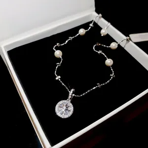 Detailed view of an elegant silver necklace featuring pearls and a sparkling star pendant.