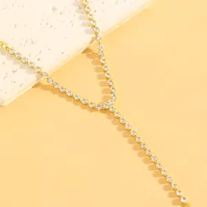 Détail macro du bracelet de main en chaîne Y dorée avec pierres de zircone carrées