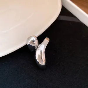 Detailed macro shot of a silver metallic ring featuring an irregular, distorted organic shape
