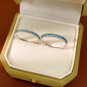 Minimalist thin eternity ring set with sparkling light blue cubic zirconia stones.