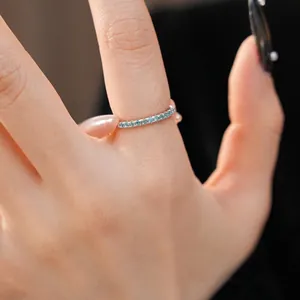 Minimalist silver eternity ring with blue zircon stones worn on finger