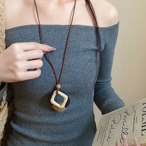 Detail view of a bohemian wood and hemp rope diamond pendant necklace