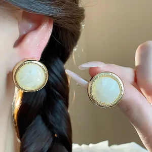 Macro view of vintage round resin earrings with textured gold metal trim