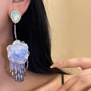 Eleganti orecchini pendenti a fiore in resina con perno a goccia e nappe.