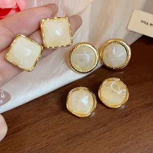 Detailed close-up of vintage geometric resin earrings featuring elegant gold-tone borders.