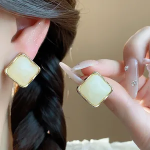 Detailed view of elegant square resin stud earrings with gold-plated borders.
