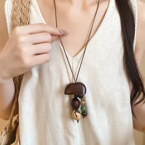 Detailed view of earthy Maillard style necklace featuring natural wood pendant and stone beads