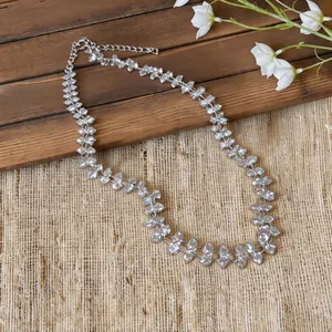 Close-up of an ethereal crystal flower necklace on a rustic wood and burlap background.